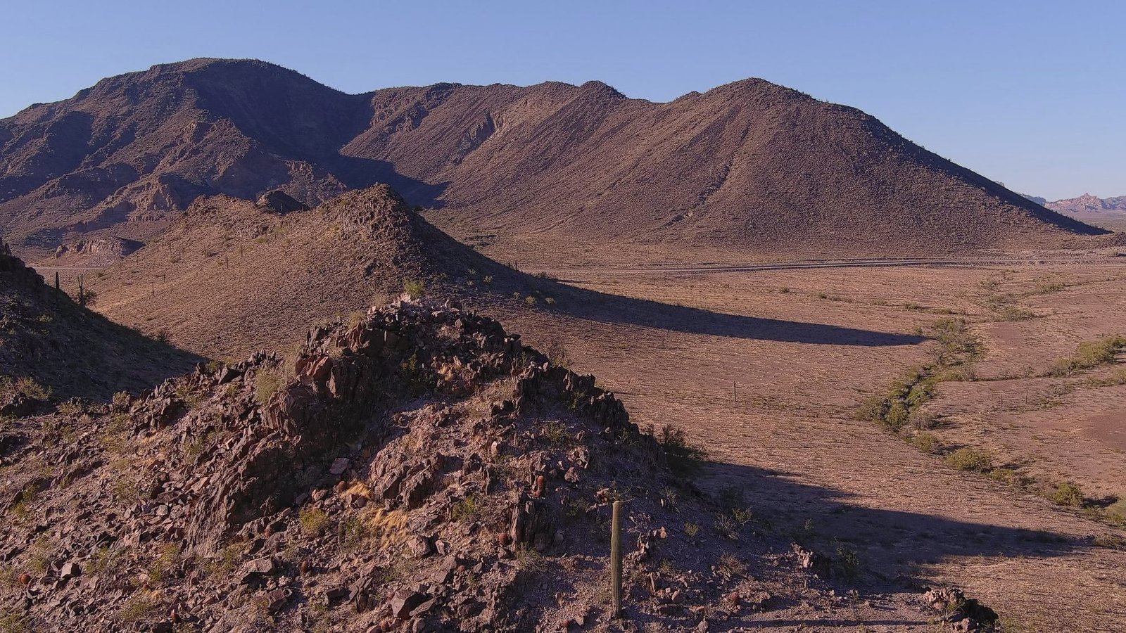 Bare desert hills with a dirt track running between them.